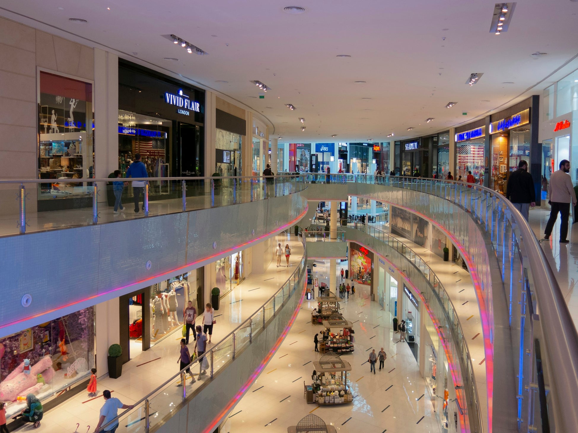 Interior of a large Dubai shopping mall showing multiple storefronts across several floors, representing GCC retail distribution routes