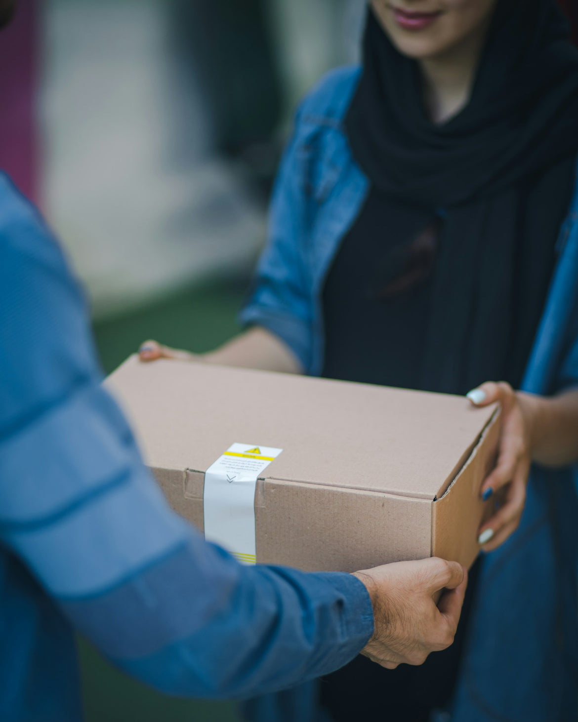 A packed parcel being handed over before dispatch, the window in which a fashion order can still be corrected
