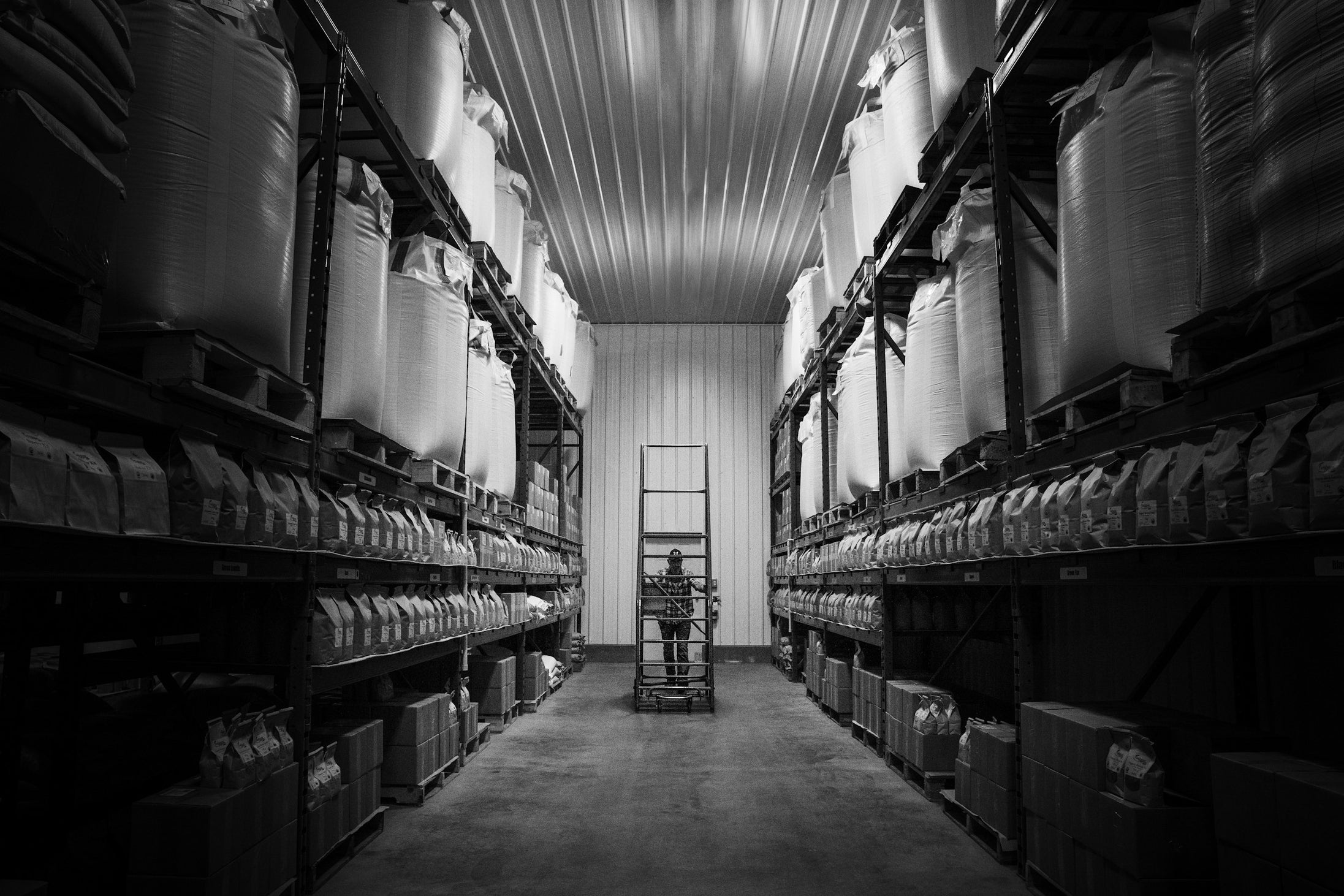 Rows of warehouse shelving stacked with boxes, representing the production and stock capability a brand needs before taking on wholesale orders